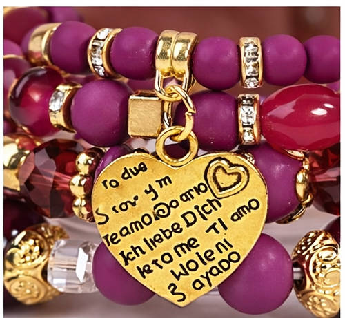 Gros plan du pendentif cœur et des perles fuchsia et dorées