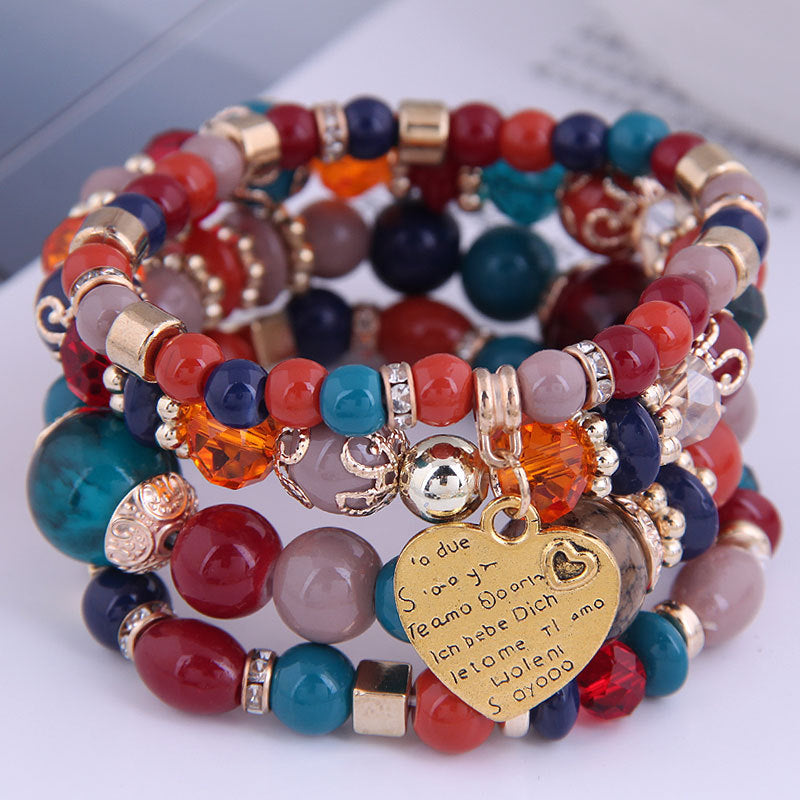 Ensemble de 4 bracelets multirangs multicolores avec perles rouges, bleues et orangées, détails dorés et pendentif cœur