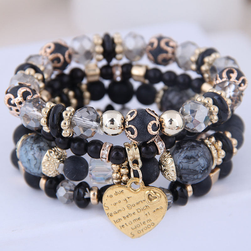 Ensemble de 4 bracelets multirangs noirs et gris avec perles, détails dorés et pendentif cœur