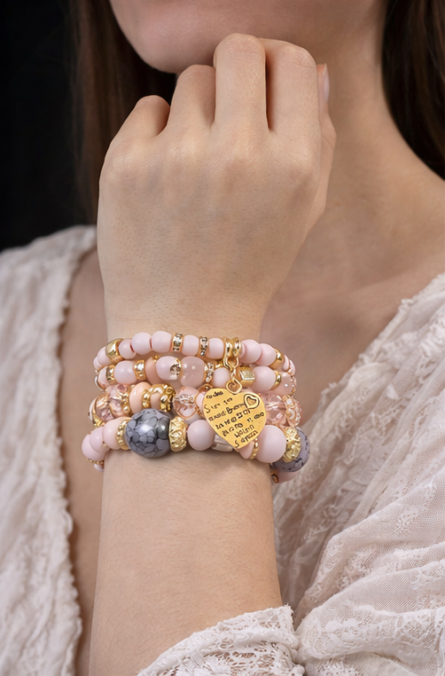 Ensemble de bracelets rose et doré porté au poignet