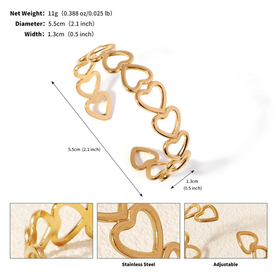 Bracelet manchette doré ouvert composé de cœurs ajourés ; l’image indique 5,5 cm de diamètre et 1,3 cm de largeur