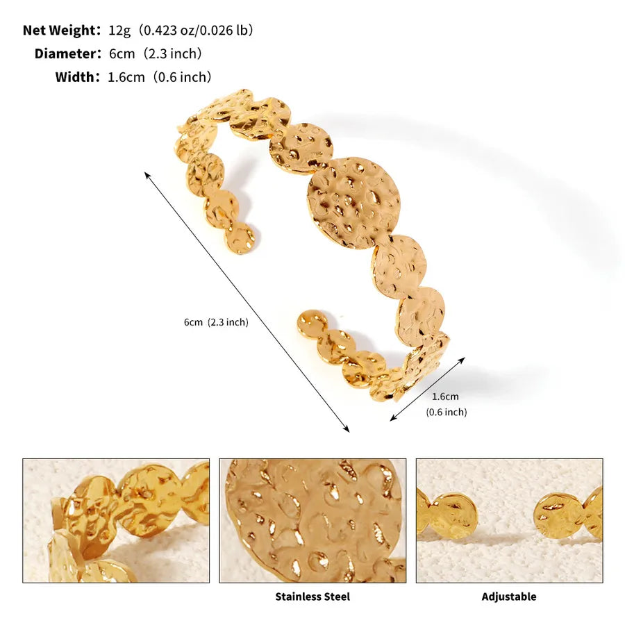 Bracelet manchette doré ouvert composé de disques ronds texturés ; l’image indique 6 cm de diamètre et 1,6 cm de largeur