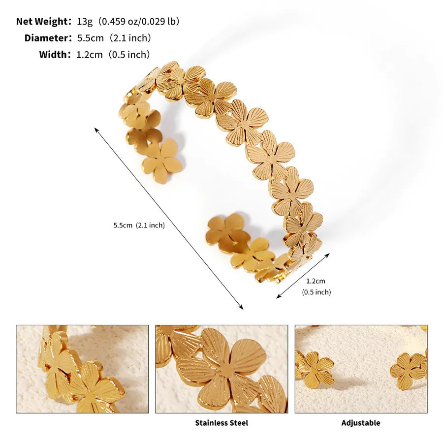 Bracelet manchette doré ouvert composé de fleurs à cinq pétales ; l’image indique 5,5 cm de diamètre et 1,2 cm de largeur
