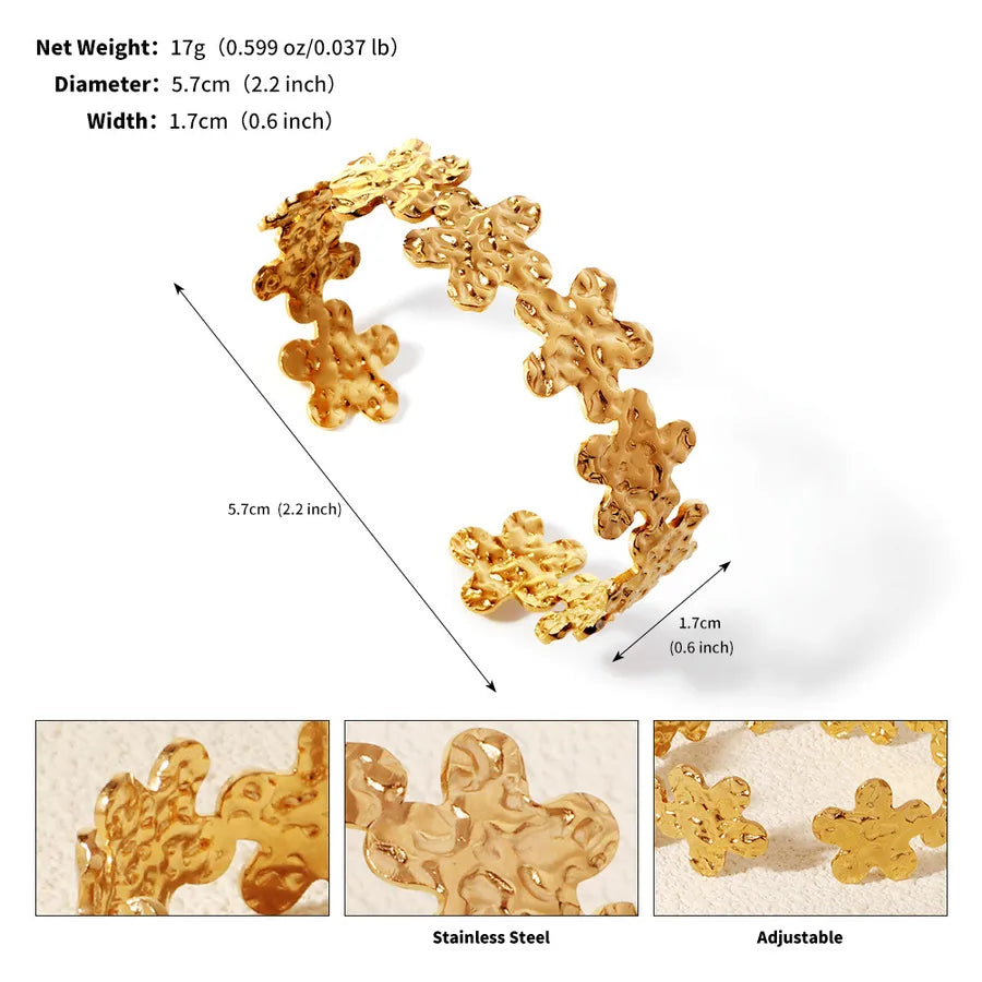 Bracelet manchette doré ouvert composé de fleurs à surface texturée ; l’image indique 5,7 cm de diamètre et 1,7 cm de largeur